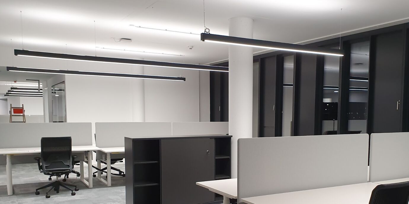 Leeres Büro mit modernem Büro-Mobiliar und Langfeldleuchten an der Decke