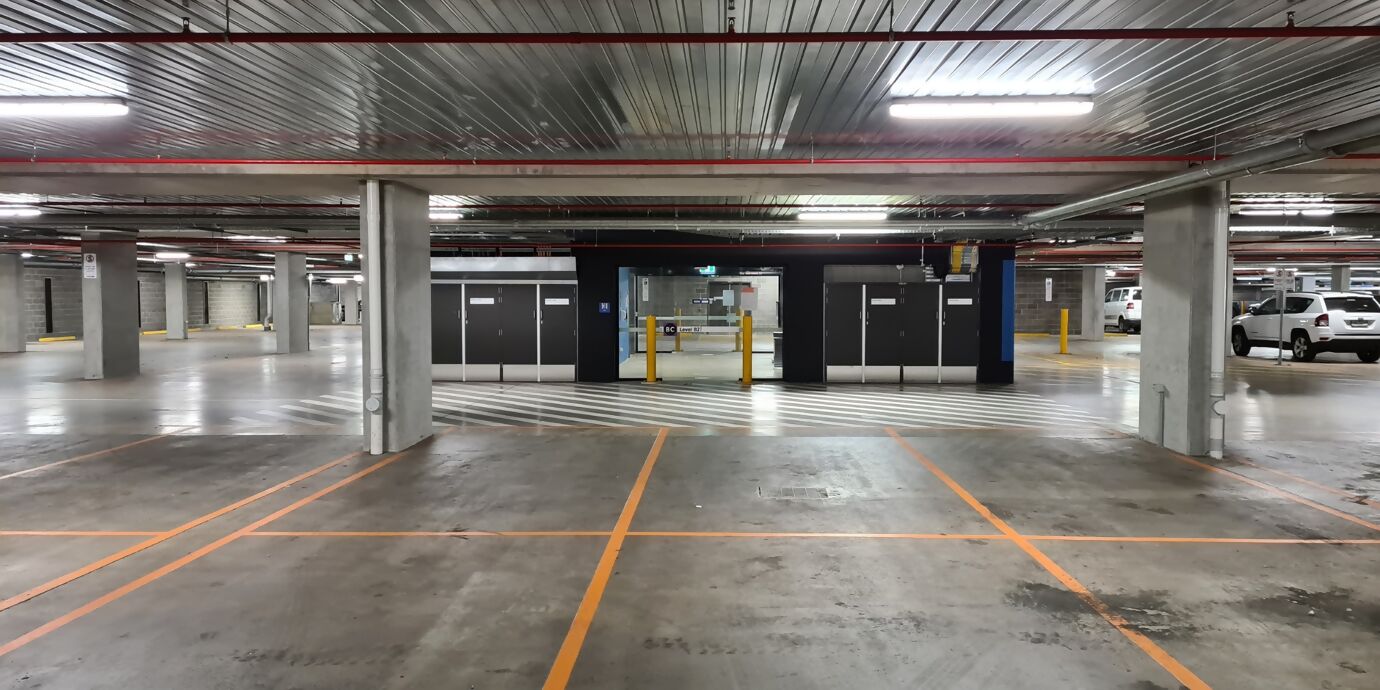 Leeres Parkhaus mit klar sichtbarer Deckenbeleuchtung, die den gesamten Bereich gleichmässig ausleuchtet