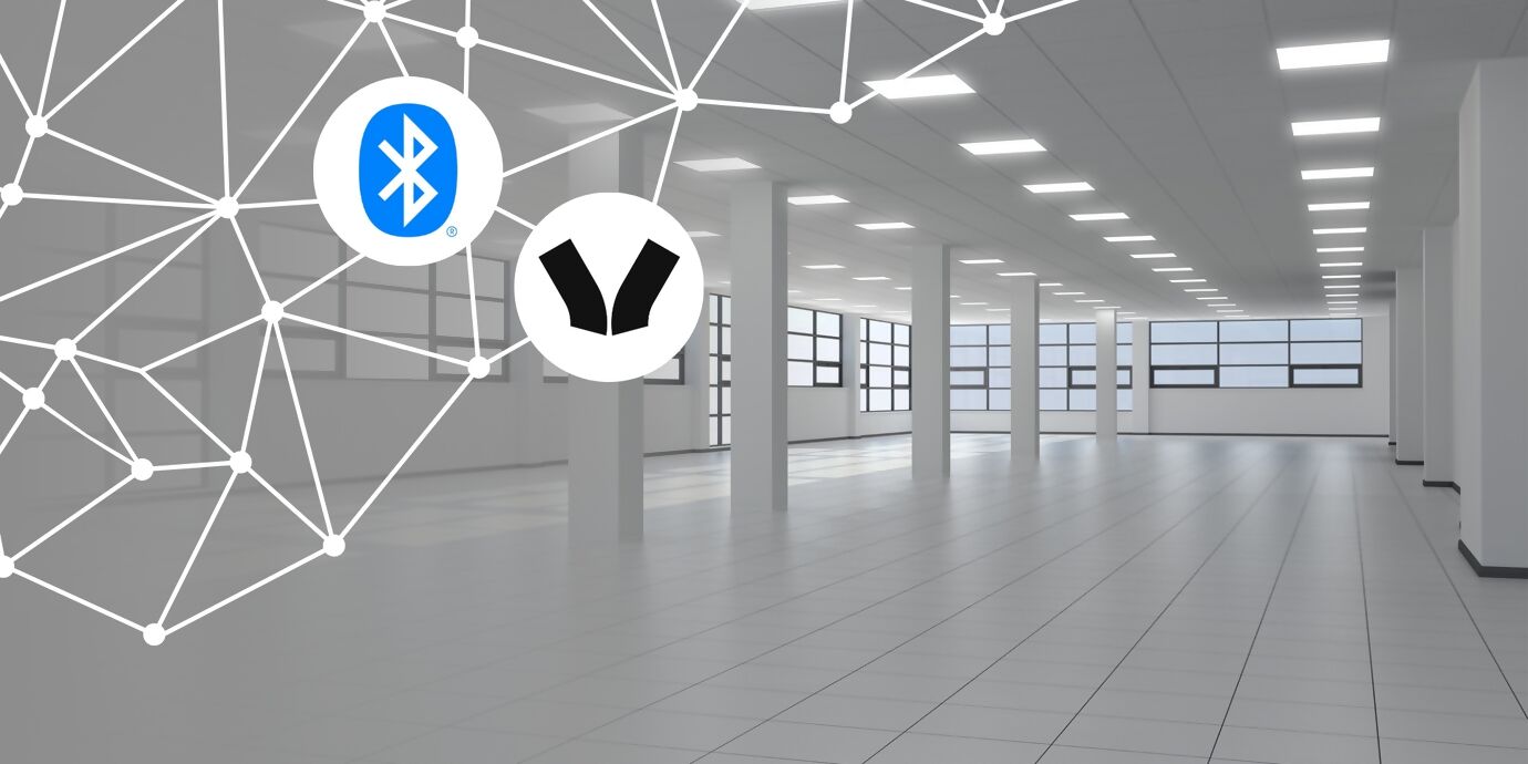 Empty, well-lit office hall in white, with a wireless network and the Bluetooth and Wirepas logos at the top left