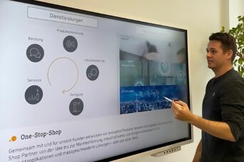 Mitarbeiter bei einer Präsentation der STEINEL vor einem grossen Bildschirm
