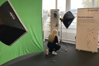 Mitarbeiterin sortiert die Kabel im internen Fotostudio