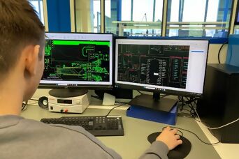 Auszubildender am Arbeitsplatz beim PCB-Design