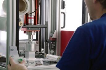 Person betätigt Maschine zum Ultraschallschweissen