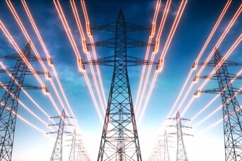 Overhead power line pylon with glowing orange electric power lines against a blue sky