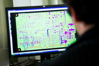 Mitarbeiter vor Monitor beim layouten einer Leiterplatte