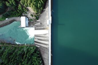 Luftansicht auf Stauseemauer (Talsperre), rechts Stausee, links Wald und Fluss