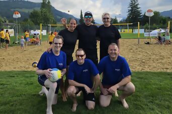 6 Personen stehen für ein Gruppenfoto vor einem Beachfeld
