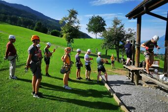Eine Gruppe von Personen steht in der Wiese und auf Übungsvorrichtungen für erste Instruktionen