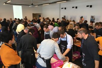 Ein Raum voll mit Personen, die in Gruppen an Lebkuchen-Kreationen arbeiten
