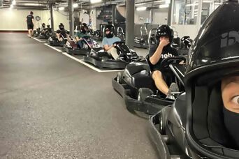 6 Mitarbeiter mit Helm, startklar in Go-Karts