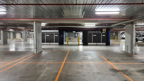 Empty car park with clearly visible ceiling lighting that evenly illuminates the entire area