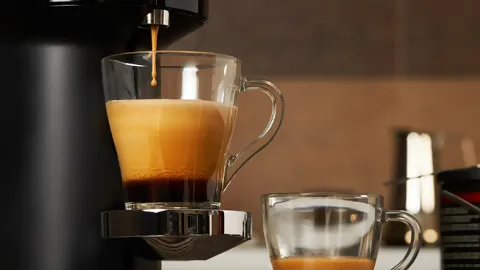 Kaffee wird aus der Maschine in den Becher gefüllt.