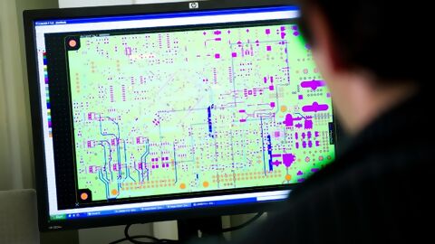 Mitarbeiter vor Monitor beim layouten einer Leiterplatte