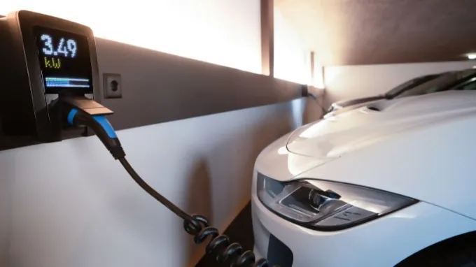 Pico e-charging station on the wall of a garage and a car charging from it.